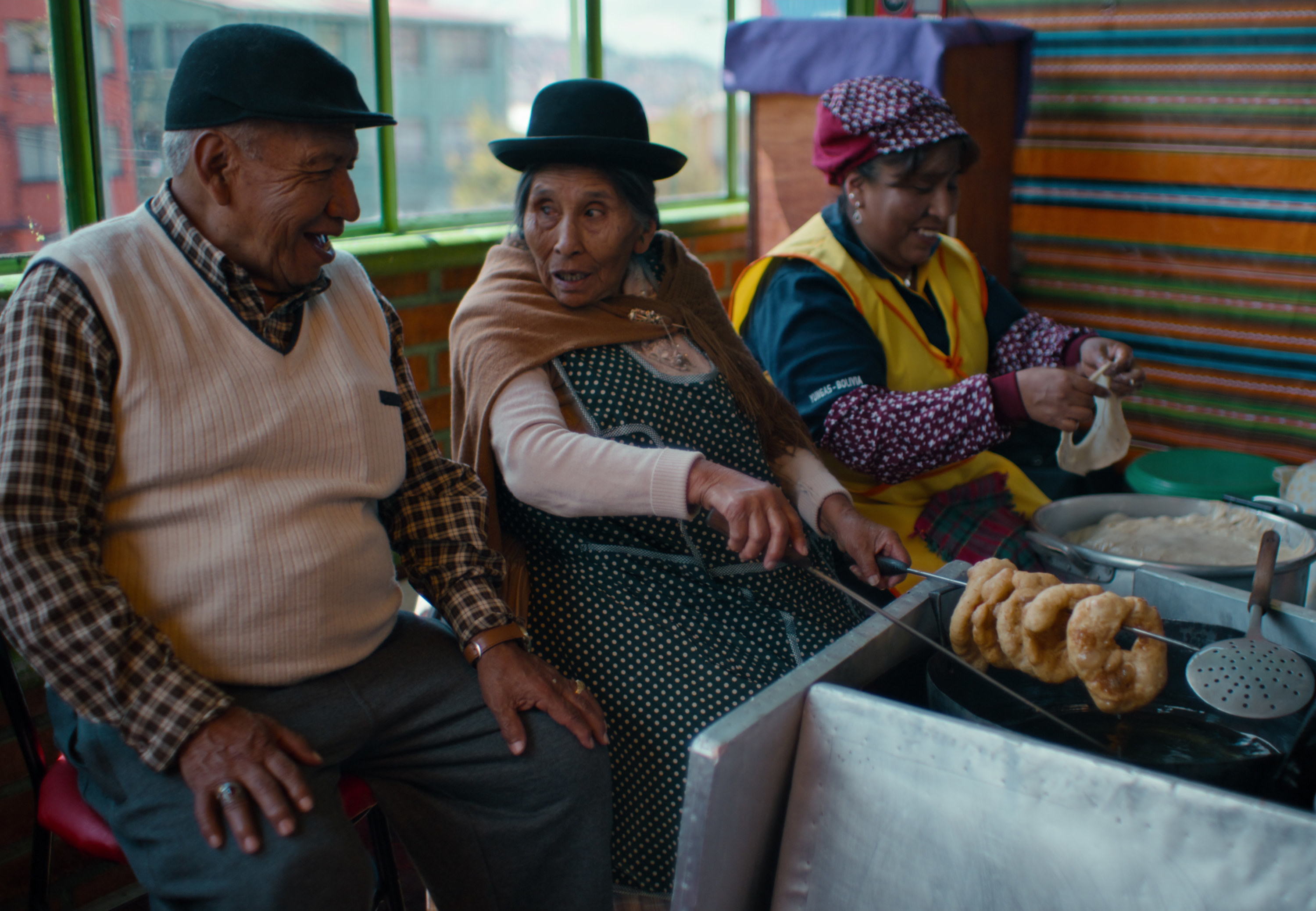 Three people cook street food. 