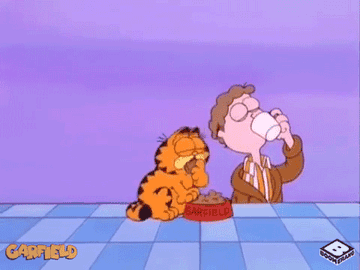 Garfield, Odie, and Jon from the cartoon &quot;Garfield&quot; having breakfast together