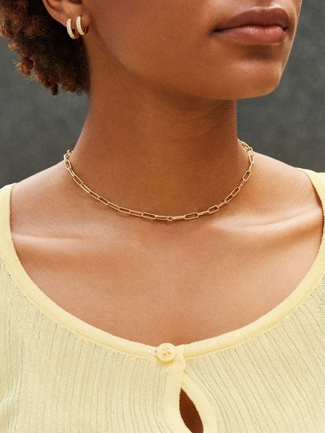 model with scoop yellow neckline and the small link gold necklace with a choker-like fit