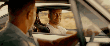 Vin Diesel and Paul Walker drive cars and exchange looks before Paul drives off in a different direction and we follow his vehicle