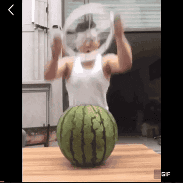 GIF of a person using the watermelon slicer to slice the fruit.