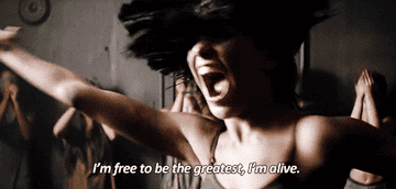 Gif of Maddie Ziegler dancing in a room full of people in a circle around her with the lyrics I&#x27;m free to be the greatest I&#x27;m alive on top