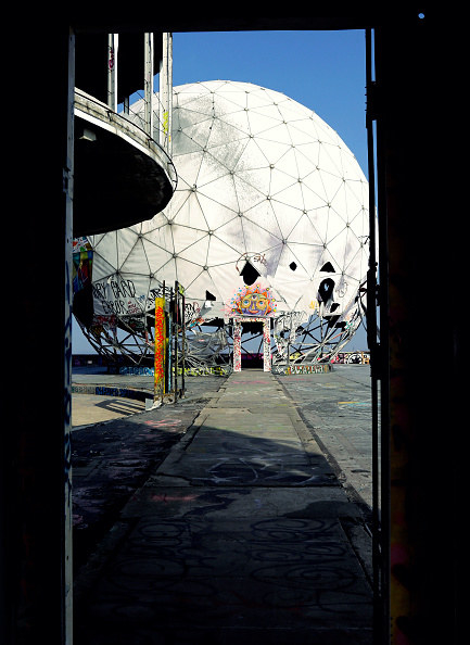 spherical white structure with graffiti and exposed base in a doorway 