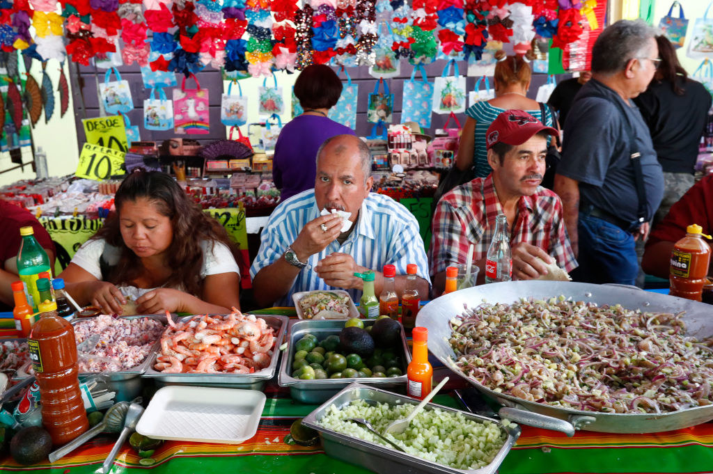 Personas comiendo mariscos en mercado de México