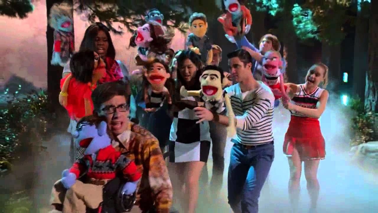 the Glee club dancing holding muppets