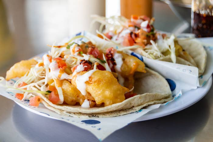 Two tacos filled with crispy tempura fish and slaw.