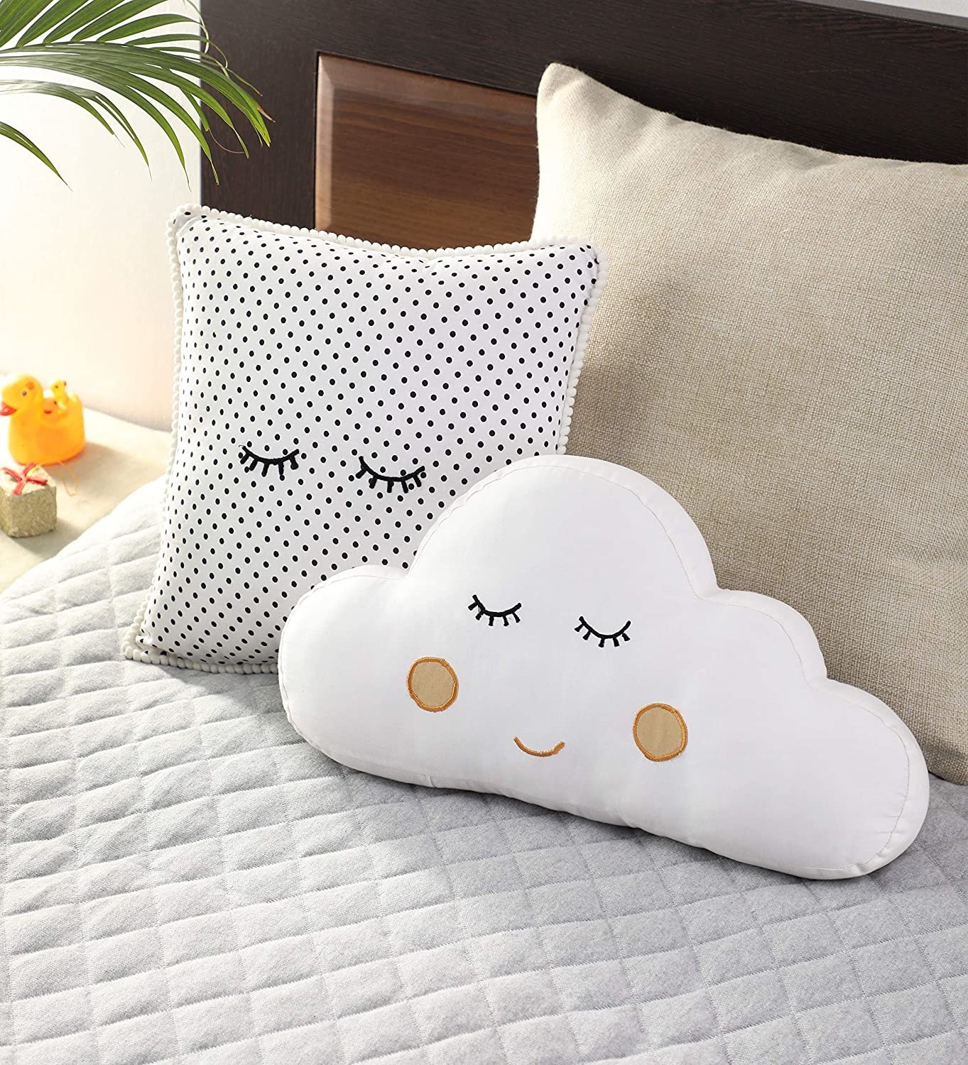 A cloud-shaped cushion, and a square-shaped cushion with a polka dot design.