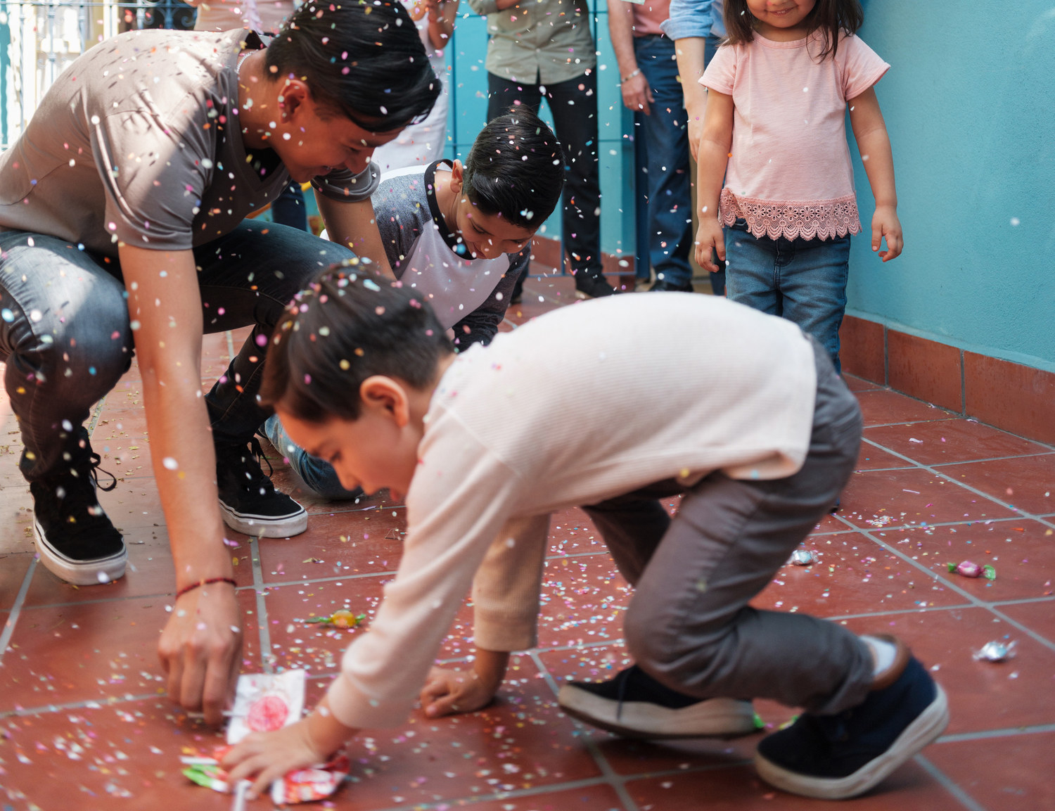 Niños recogiendo dulces de la piñata del piso