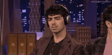 Joe Jonas bopping his head while listening to music with headphones on