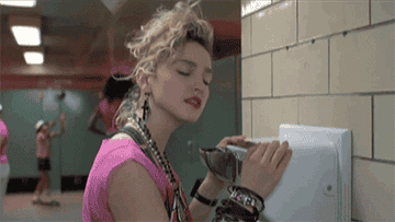 麦当娜在电影《拼命寻找苏珊》中的动图;她的头伏在浴室里的烘干机上