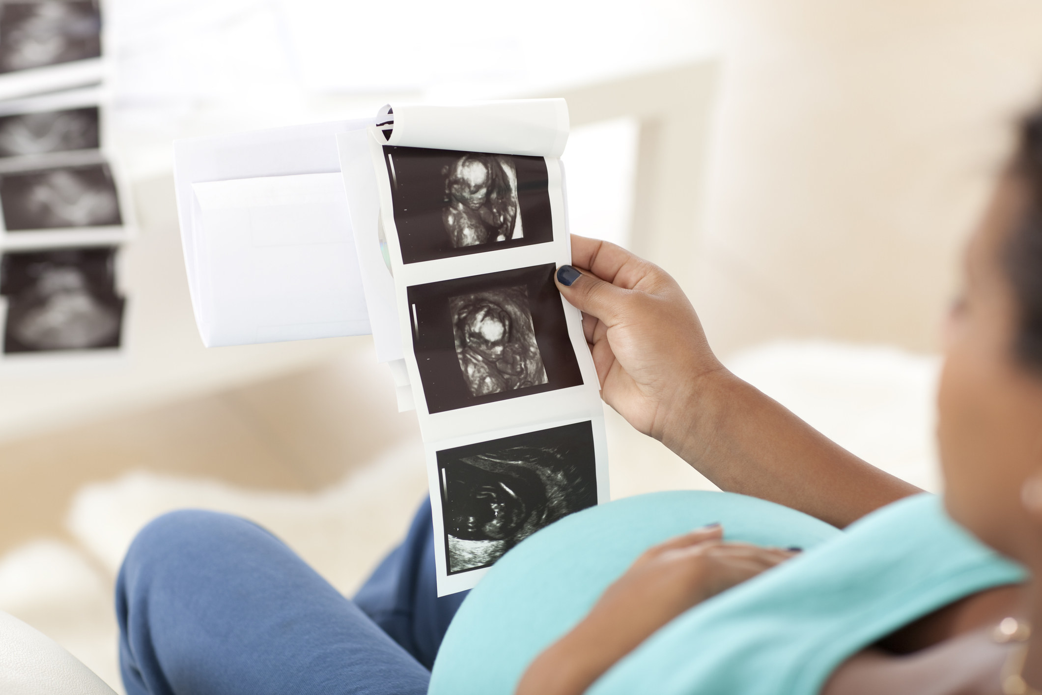Photo of a pregnant woman holding ultrasound images