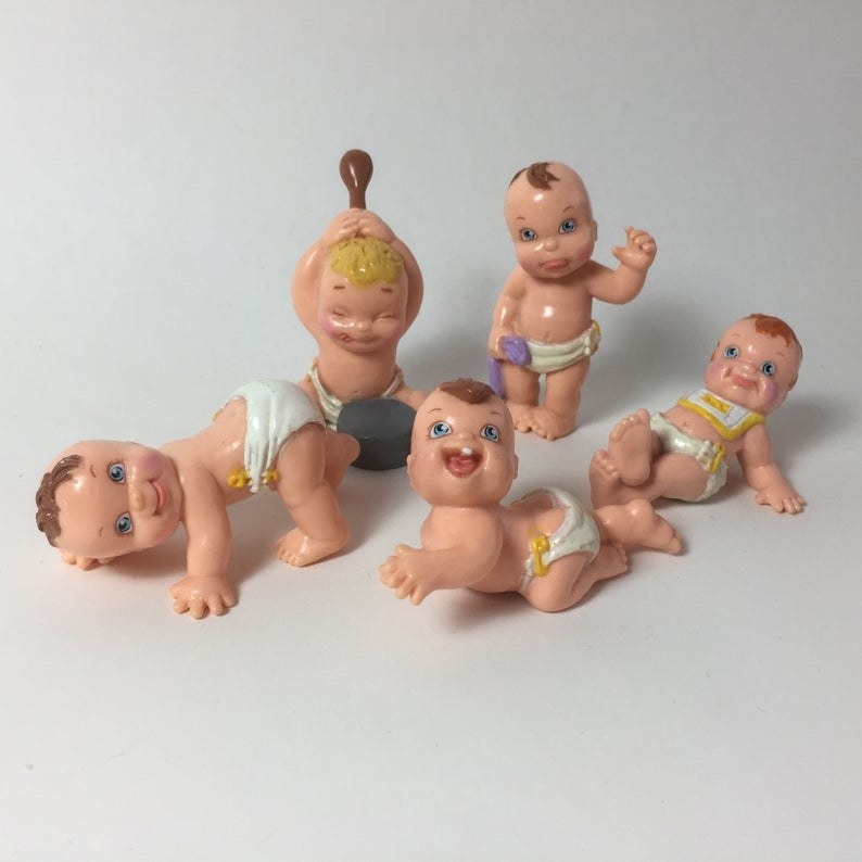 Five baby figures wearing diapers and making silly faces