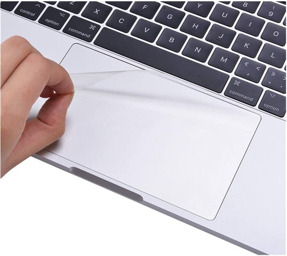 A person peeling the protector off the corner of their track pad