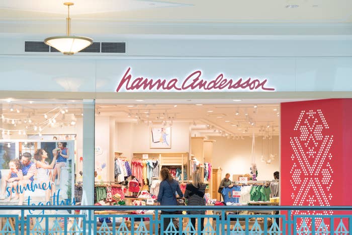 People are seen shopping through the large open door to a store in a mall