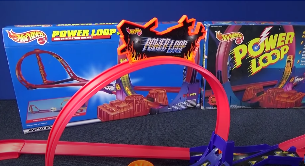 A red Matchbox Power Loop built, with two boxes for it in the background