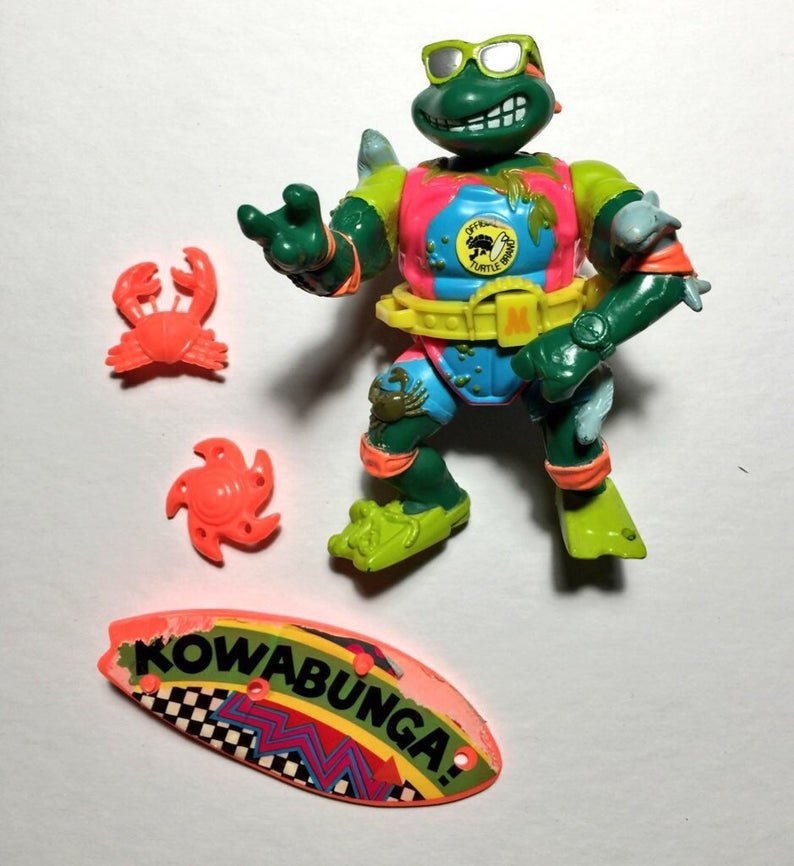 A Michelangelo action figure dressed as a surfer and wearing sunglasses