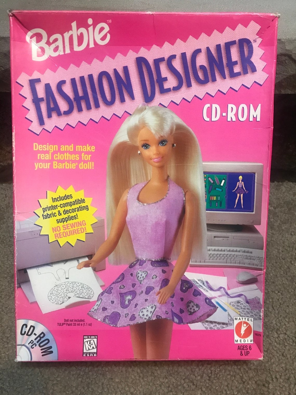 Photo of the Barbie Fashion Designer CD-ROM box which features a Barbie doll in a purple dress printing out a design