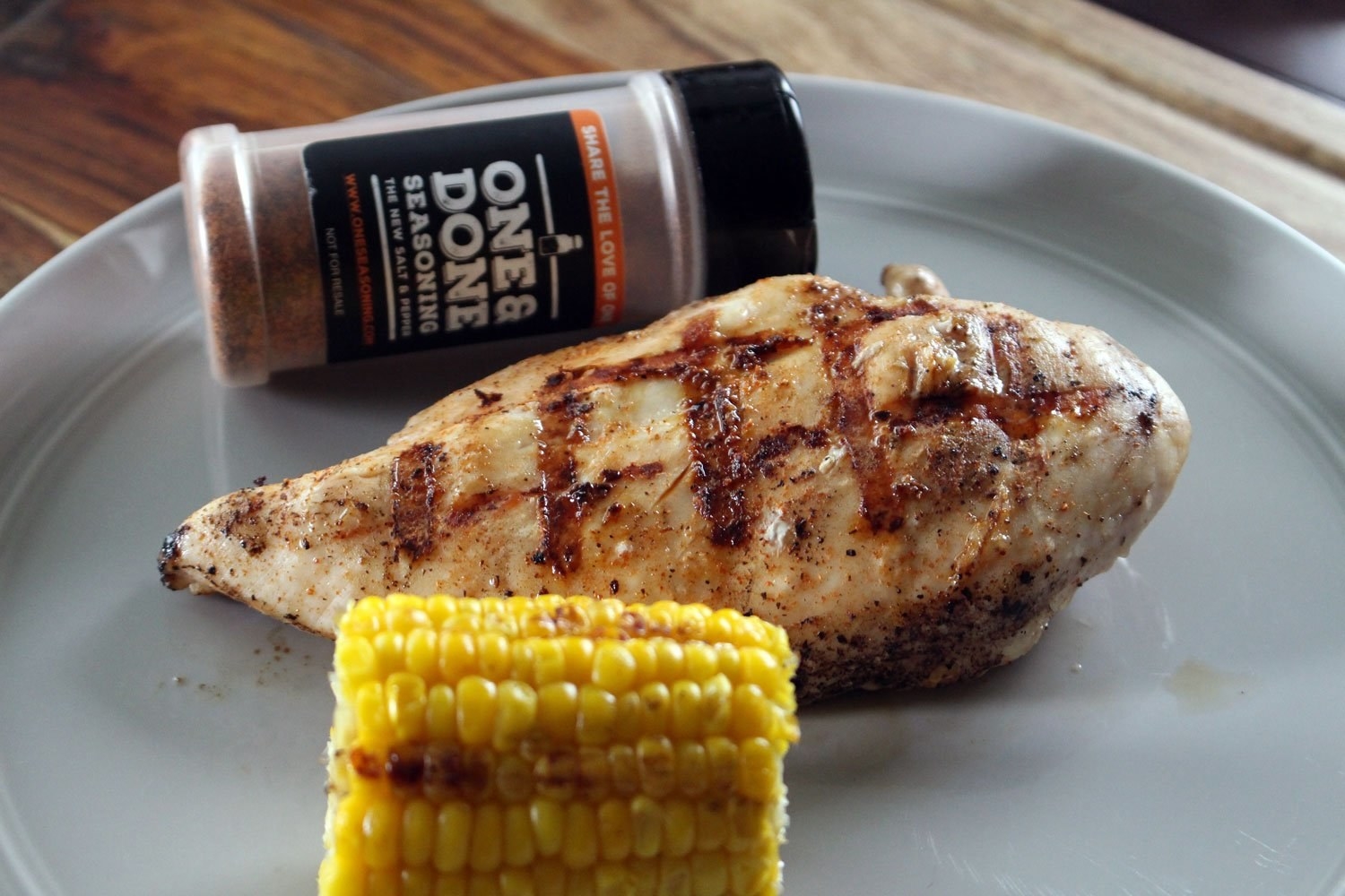 A bottle of One &amp;amp; Done All-Purpose Seasoning &amp;amp; BBQ Rub next to a plate of chicken