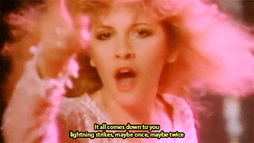 Gif of Steve Nicks pointing at camera with the lyrics it all comes down to you lightning strikes maybe once maybe twice on top