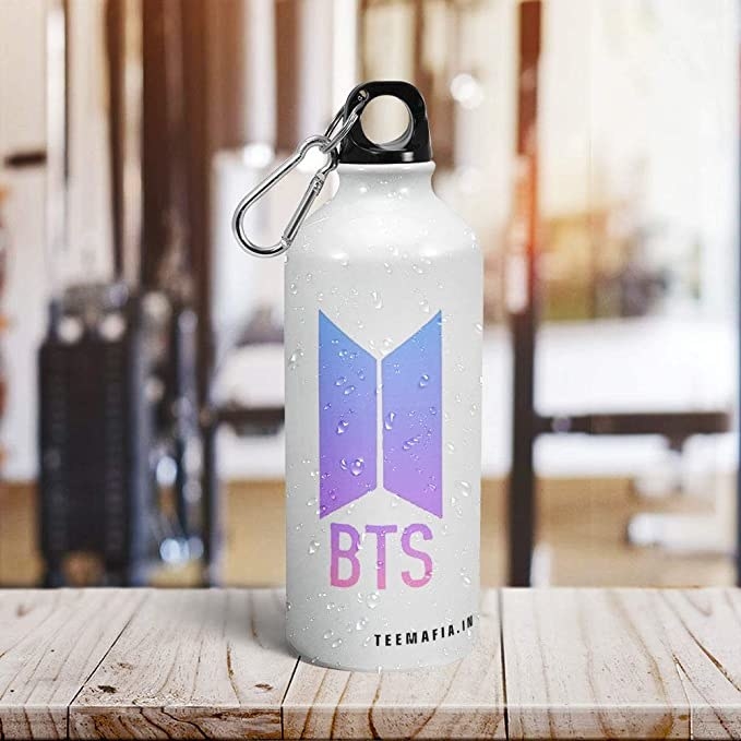 White bottle with a purple BTS logo on it.