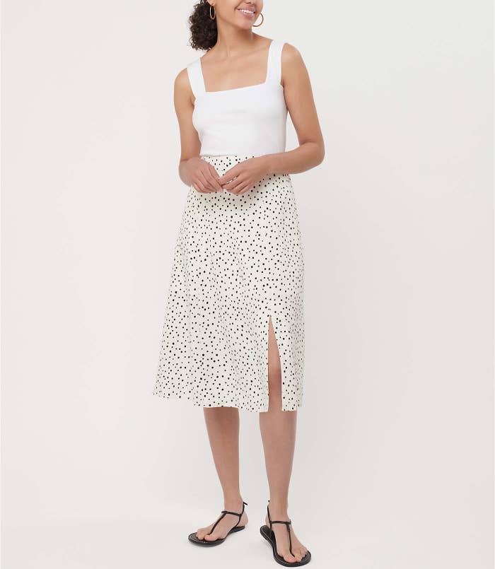 a white midi skirt with tiny black polka dots and a slit up the side