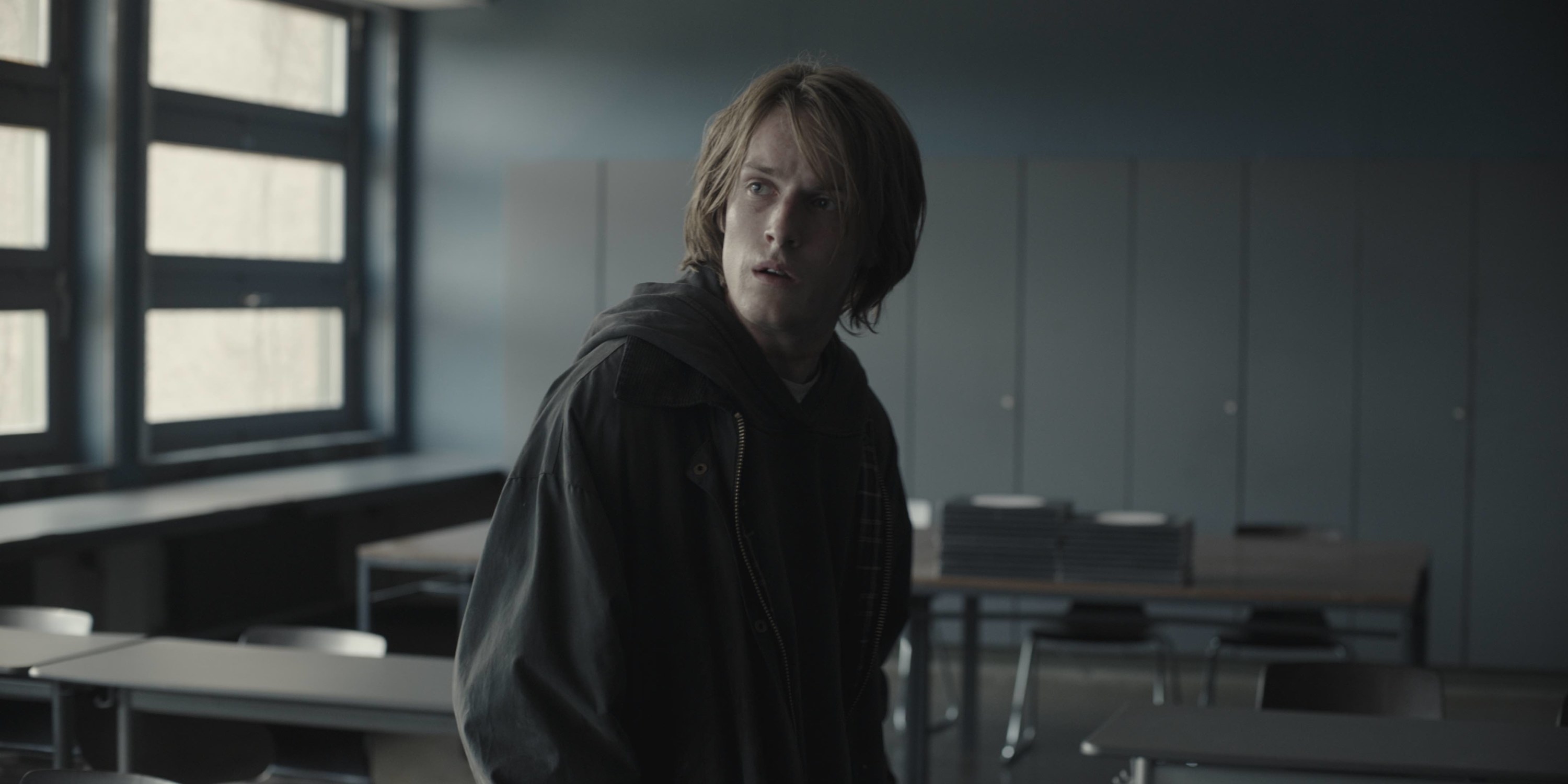 Louis Hofmann as Jonas sitting in an empty classroom in Season 3, Episode 1 of &quot;Dark&quot;