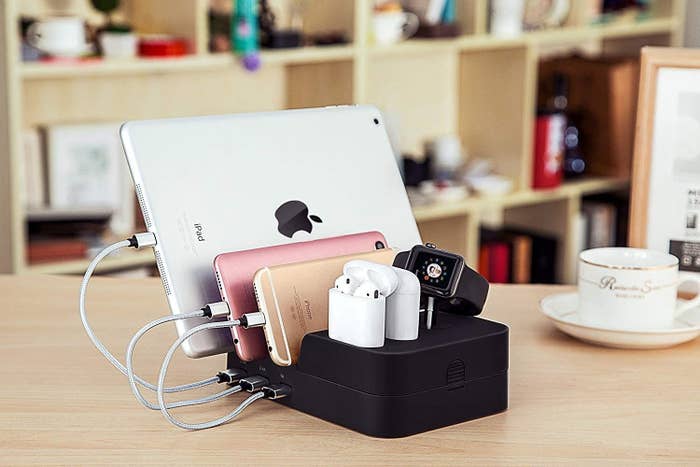 An iPad, two iPhones, two sets of AirPods and an Apple watch charging on the dock