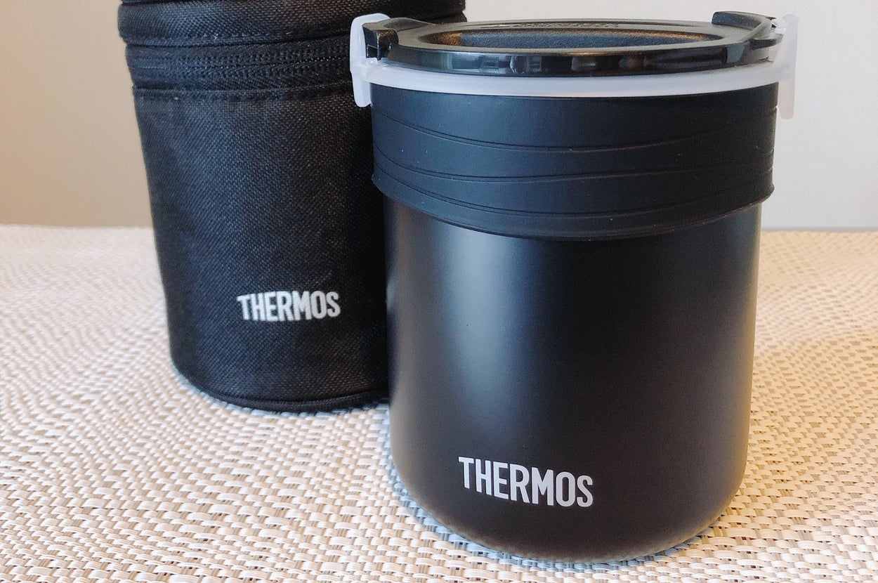 サーモスの魔法瓶と専用ケースがテーブルの上に置いてあります。