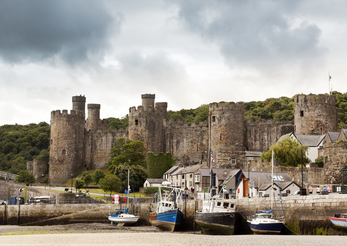 The habour with sailing boats and the castle in Conwy on a grey and cloudy day