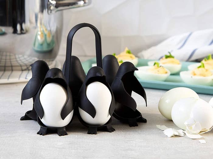 the black penguin-shaped holder with eggs inside