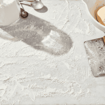 gif of hand cleaning flour off a counter with white and blue sponge cloth