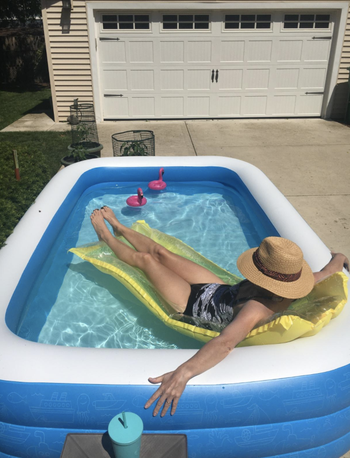 a reviewer laying in a pool float in the pool