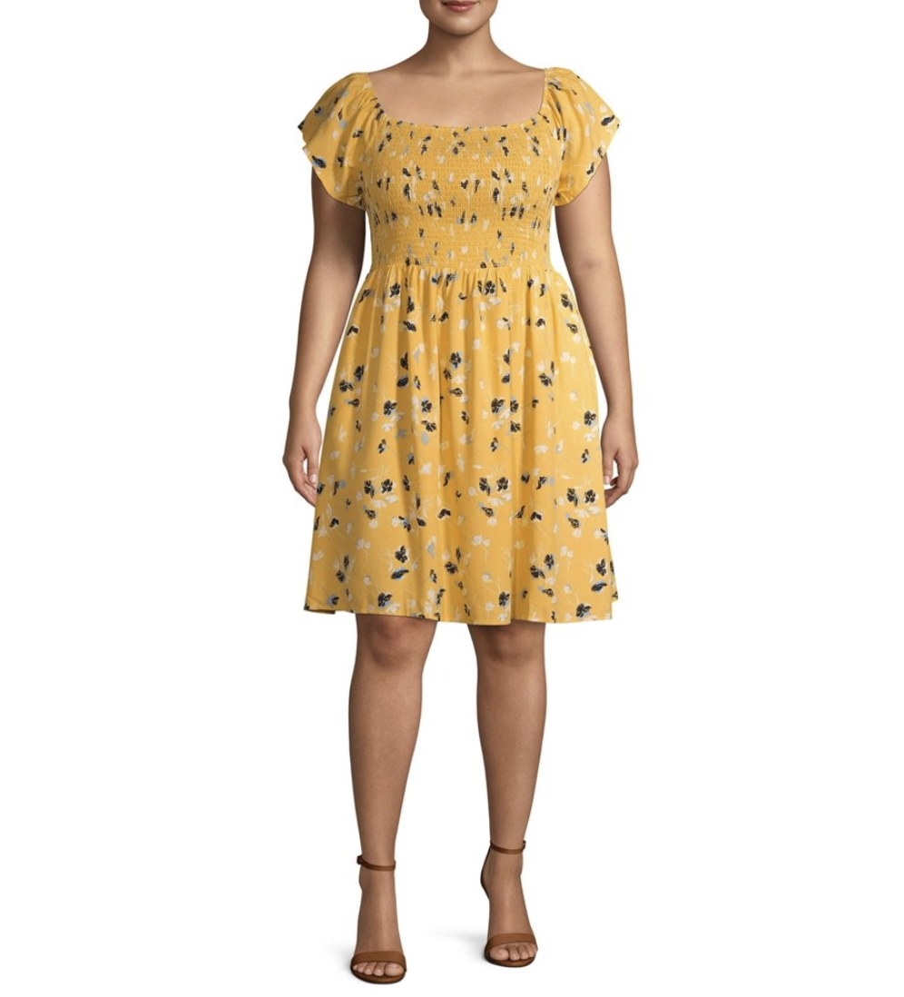 A model in a yellow smocked sleeve dress with floral print 