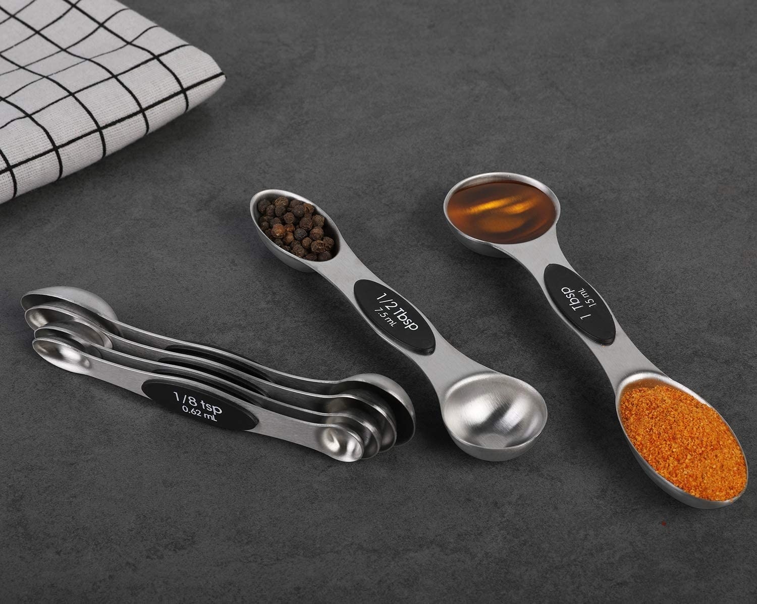 The set of measuring spoons holding different amounts of different ingredients