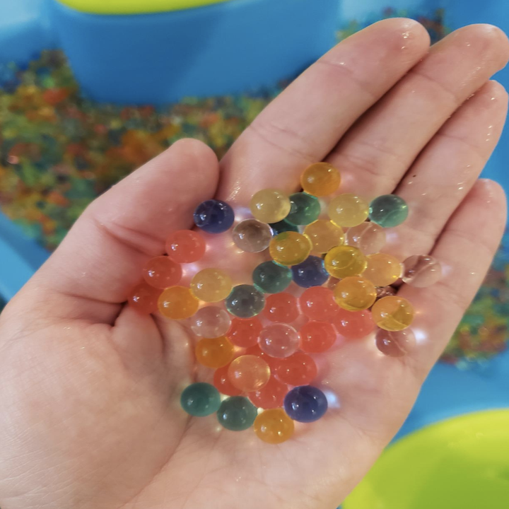 A reviewer holding up the water beads expanded in their hand 
