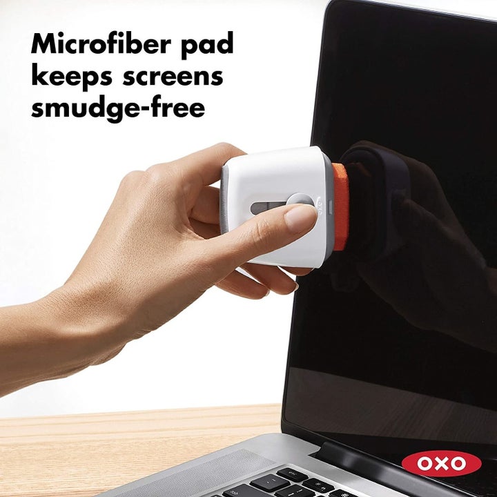The model's hand using the microfiber side to clean their screen, with the text "Microfiber pad keeps screens smudge-free"