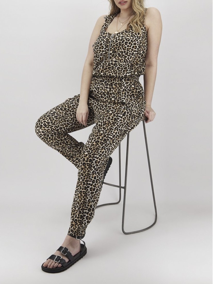 A model in a sleeveless cheetah print jumpsuit with pants that go to the ankle 