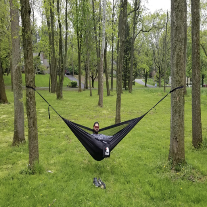 a reviewer in the black hammock between two trees