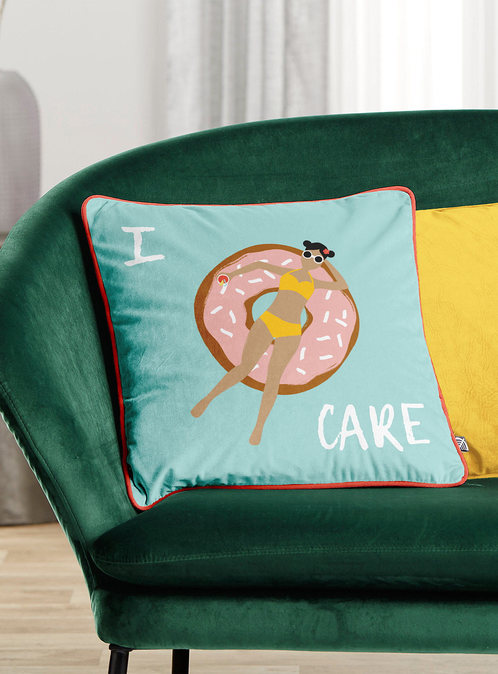 A cushion with the print of a person swimming on a donut floatie