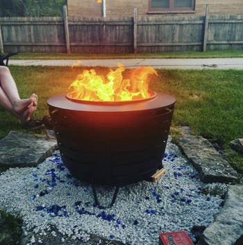 the larger, round fire pit with a fire going