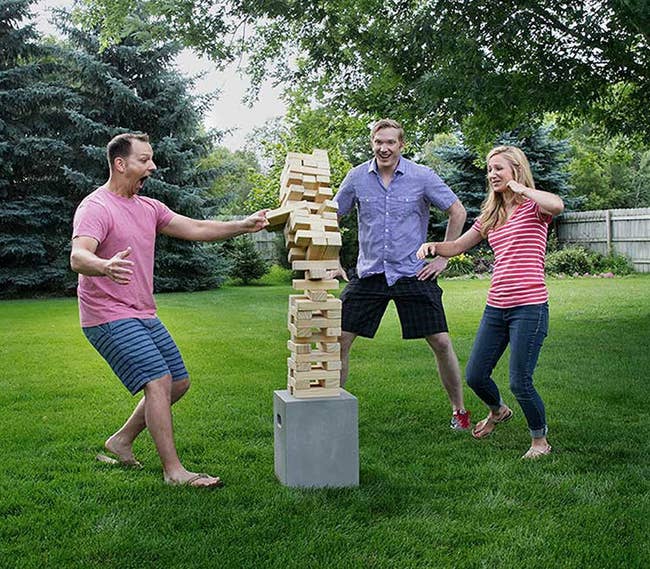 three models playing with the stackable tower of blocks
