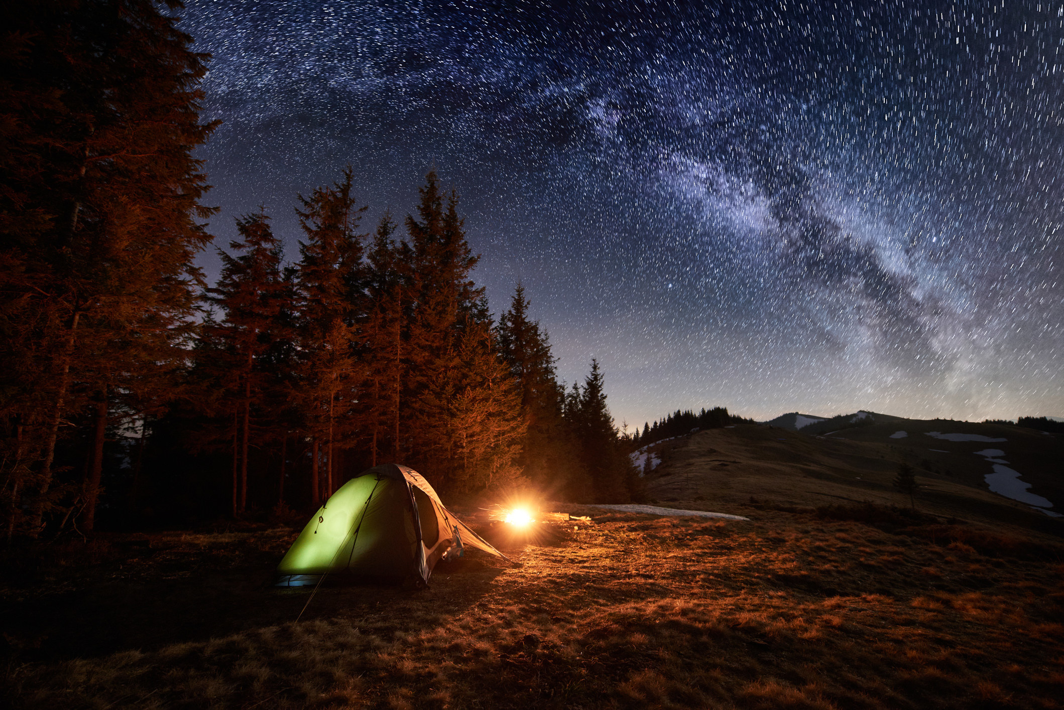 Illuminated tent under a starry night sky