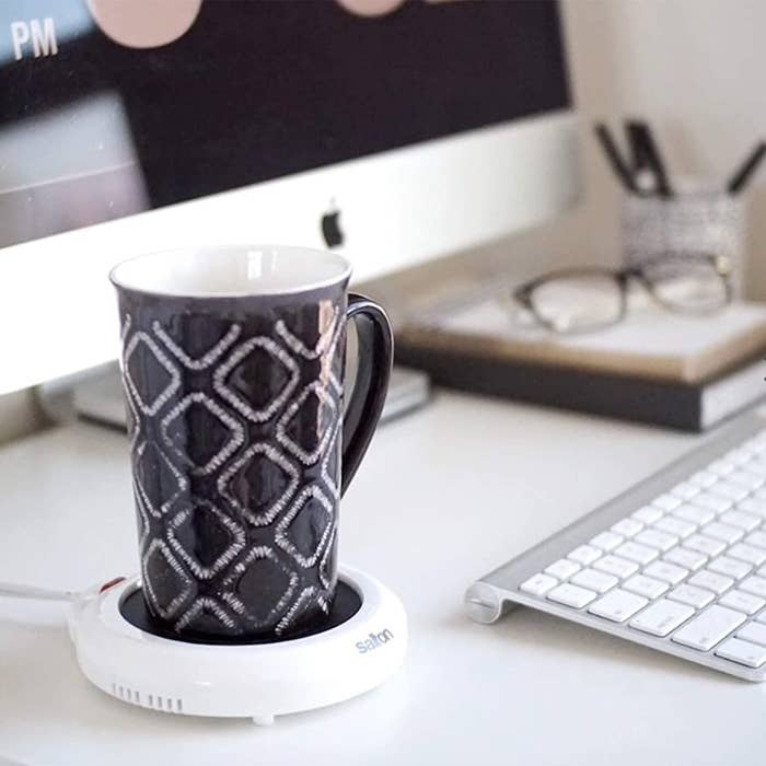 An electric mug warmer with a patterned mug on top of it
