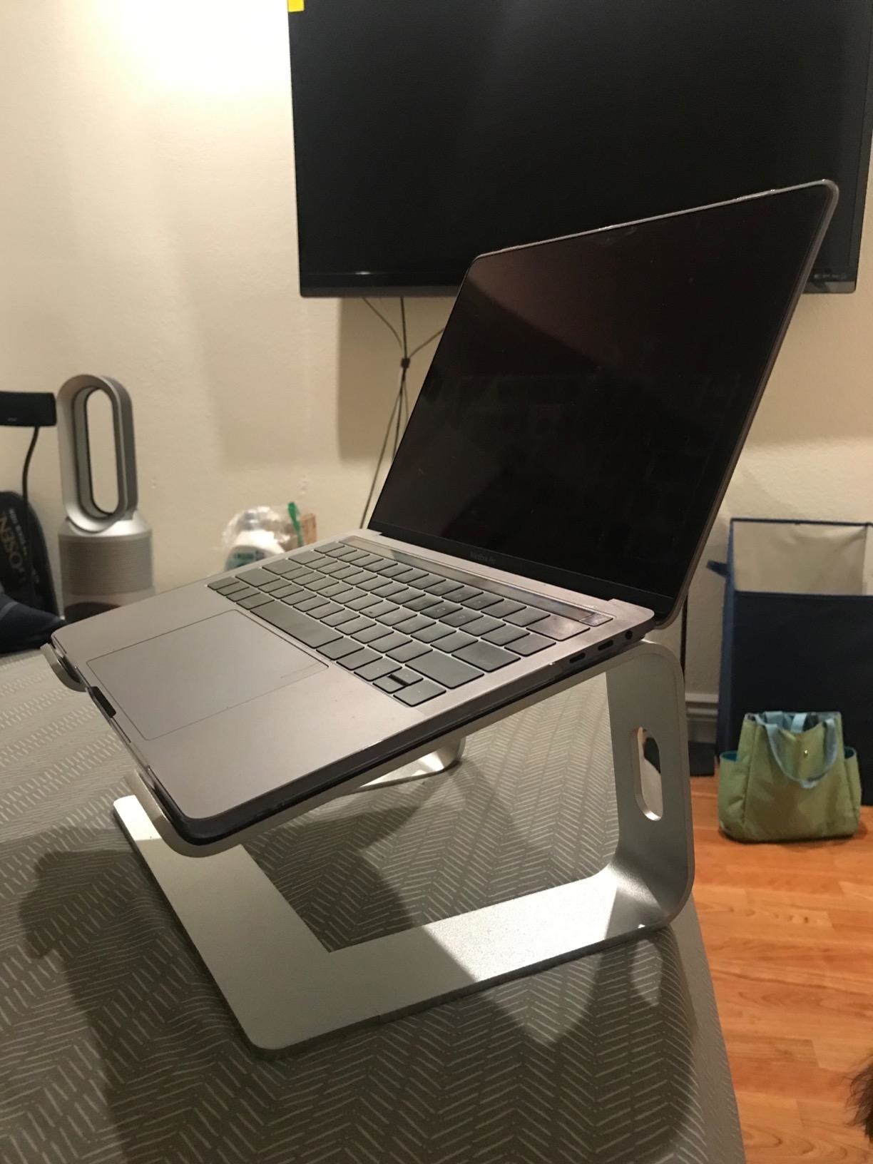 Reviewer photo showing the laptop stand in use, which tilts slightly downward 