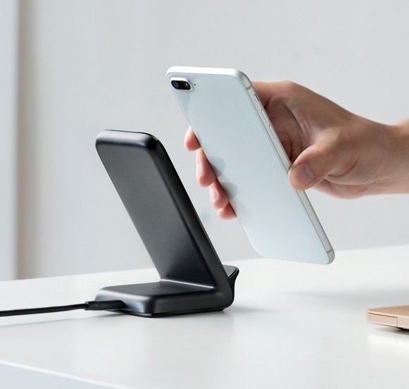 A person placing their phone onto the charger