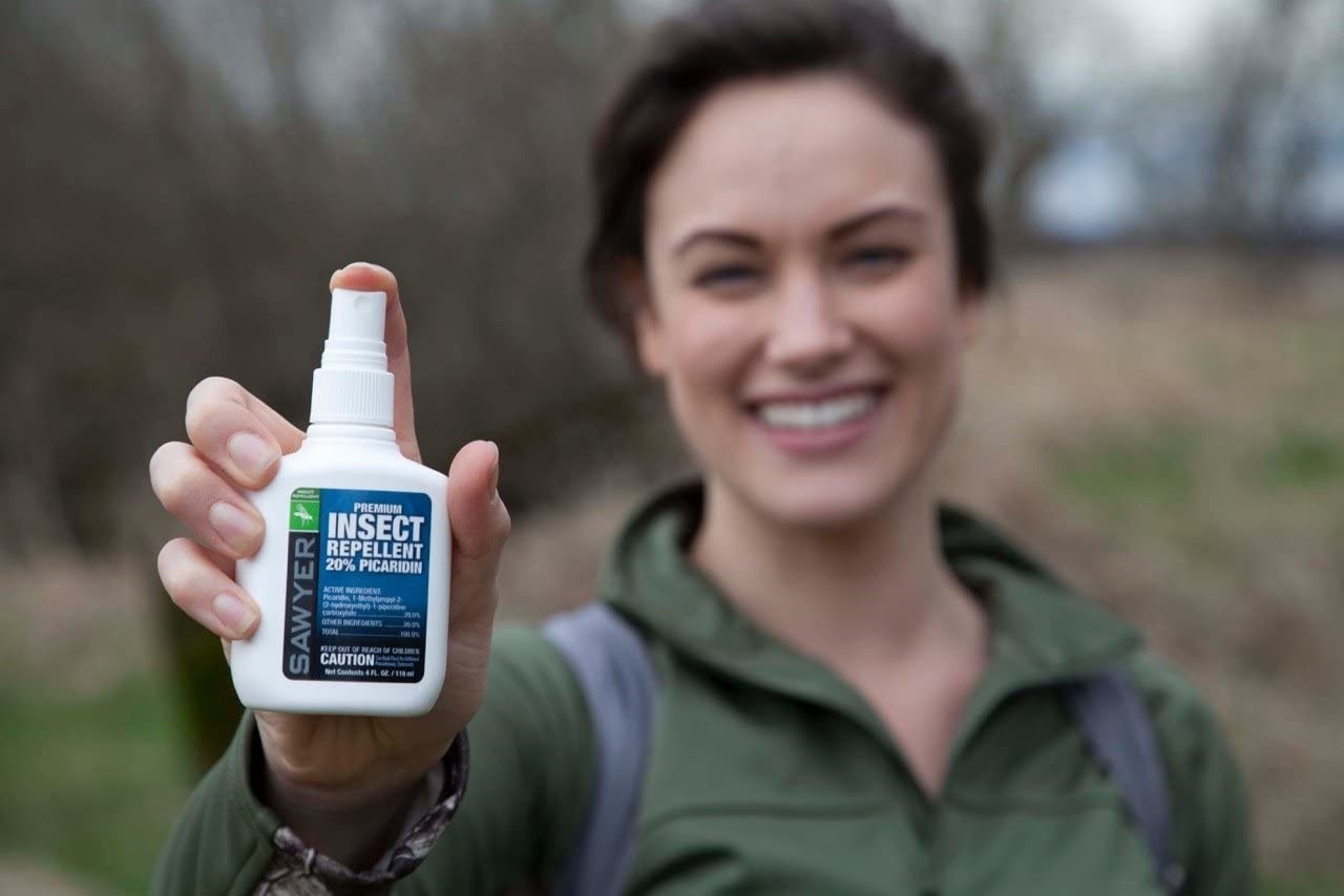 Model holding the bottle of insect repellent 