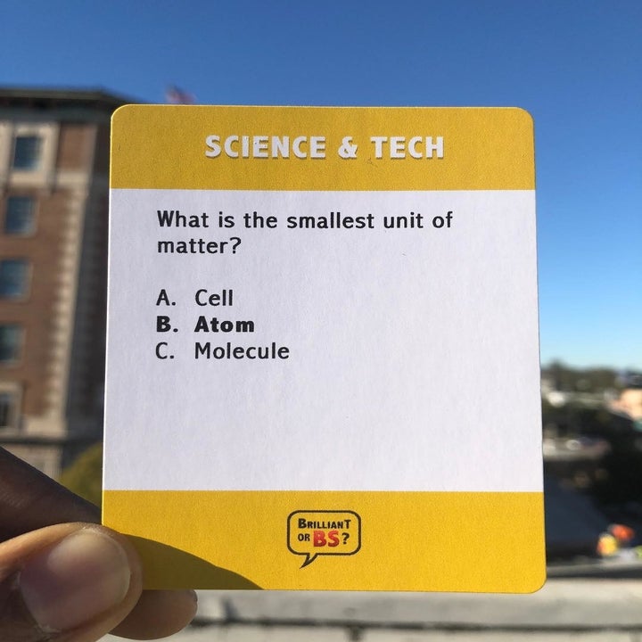 person holding up a game question card 