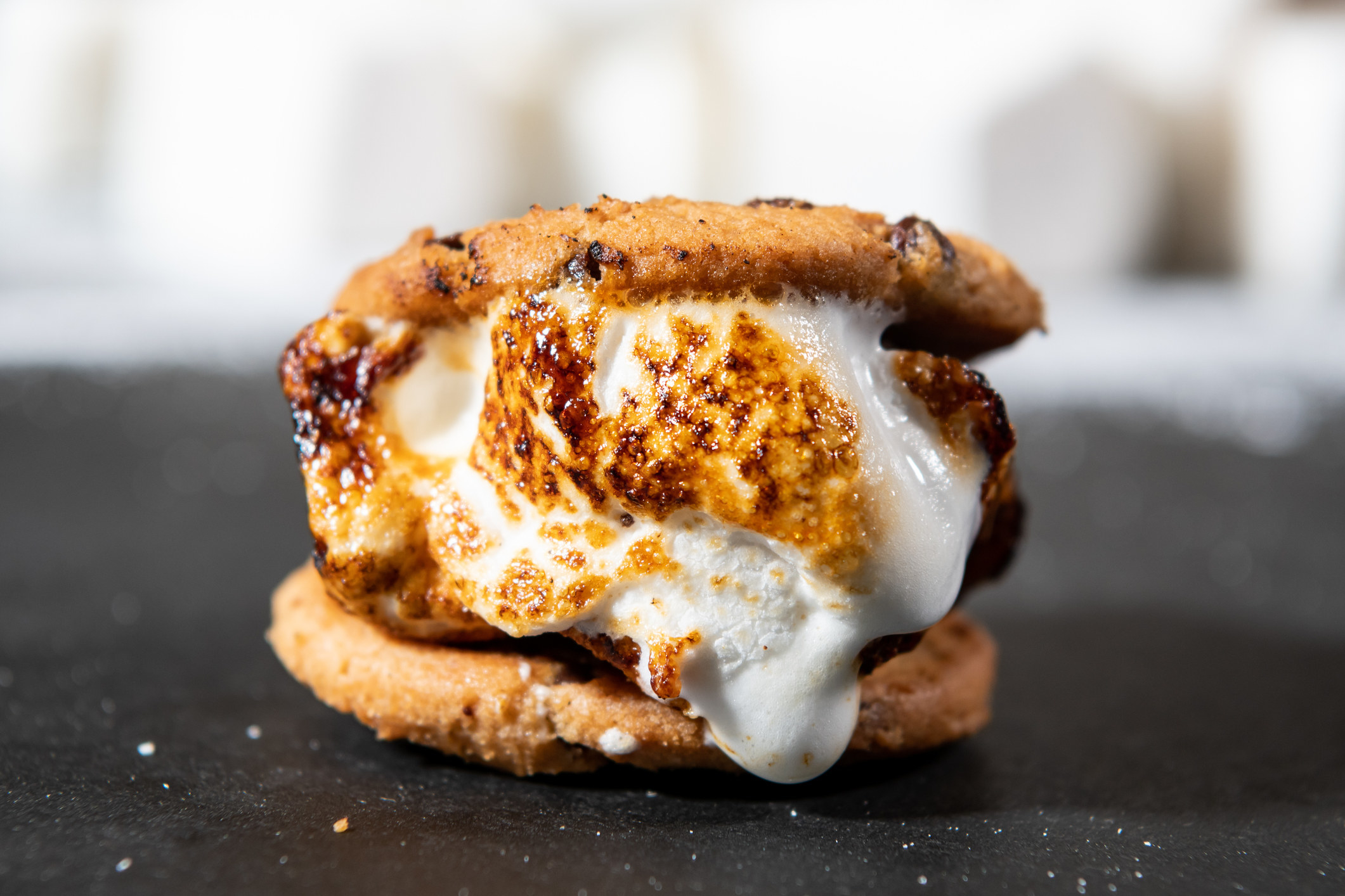 A s&#x27;more made with marshmallow, chocolate, and two chocolate chip cookie.