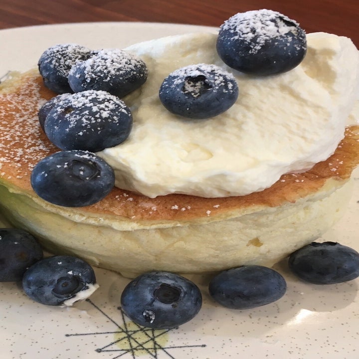 fluffy soufflé pancake topped with cream and blueberries