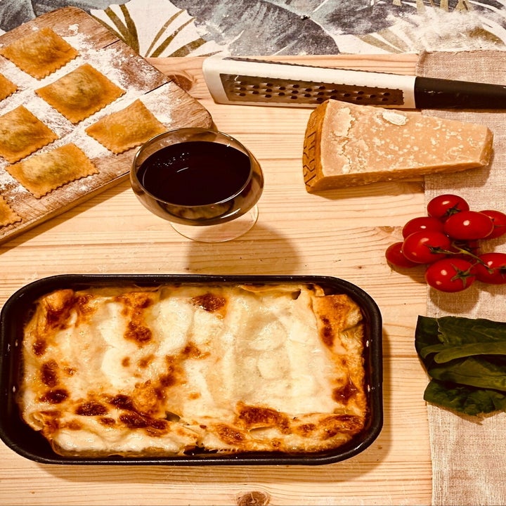 fresh ravioli, dish of lasagna, glass of red wine, parmesan cheese
